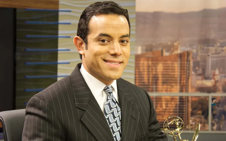 News anchor with Emmy award in studio.